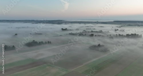 Łąki o poranku, zielone użytki podczas wschodu słońca pokryte mgłą i życie budzące się z nocnego snu. Mgła o poranku, wschód słońca o poranku gdzie zielone łąki są schowane za mgłą.  photo