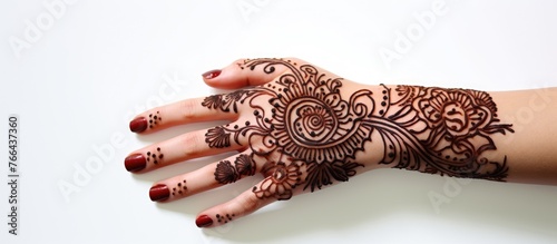 A person's hand is elegantly decorated with a traditional henna tattoo design
