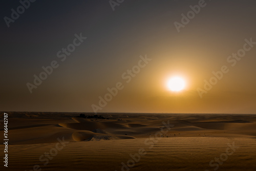 Beautiful dramatic clouds sunset sunrise over the desert sand dune of Abu Dhabi photo