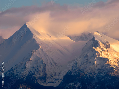 Mountains Landscape in winter. Tatra National Park- view from Czarna Gora. Mountain peaks illuminated by the rays of the setting sun shining through the clouds. Spisz. Malopolskie. Poland.