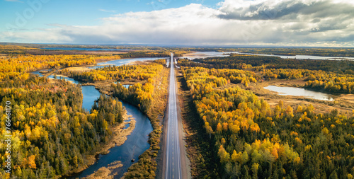 Highway Road by vibrant fall season color trees. Sunny Sky Aerial View. Newfoundland, Canada