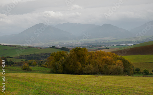 Mountain landscape. In the foreground, a farmland and autumn trees. In the distance you can see the Low Tatras Zilina Region. Liptovske Matiasovce. Slovakia. photo