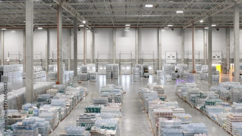 A large, spacious, bright warehouse for storing drinking water. along the shelves.