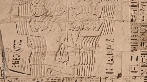 Ancient Egyptian hieroglyphs and bas-reliefs close-up in Temple of Medinet Habu. Egypt, Luxor. The Mortuary Temple of Ramesses III at Medinet Habu located in the West Bank of Luxor in Egypt.