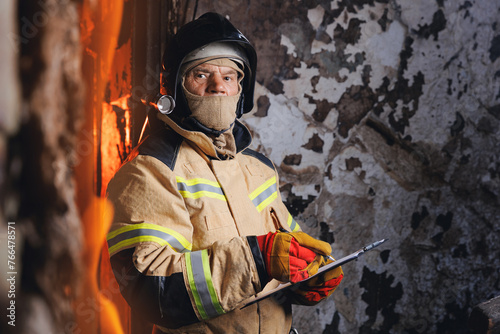Fireman inspector conducts investigation to determine circumstances of fire in house and uses clipboard for report incident. Concept Insurance payments and checklist photo