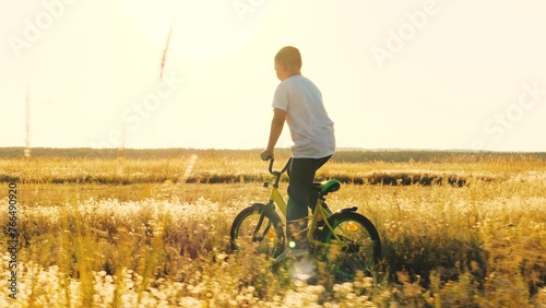 happy boy learning ride bicycle park, child schoolboy son rides bicycle sunset, happy family, cardio exercise machine, healthy active game child schoolboy sunset, spin wheel, turn foot pedal, son