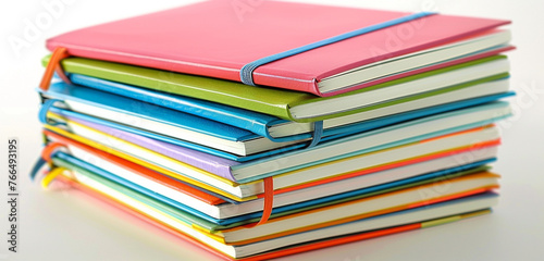 A stack of colorful notebooks, isolated on white background, blank label.