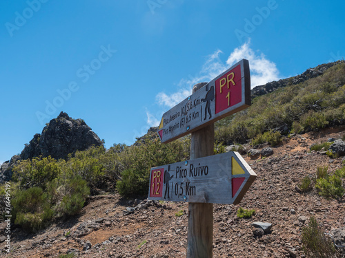 Tourist Signpost at hiking trail PR1.2 to Pico Ruivo - at 1,861 m the highest mountain and PR1 to Pico Areiro second highest peak, Madeira , Portugal. Blue sky, copy space © Kristyna