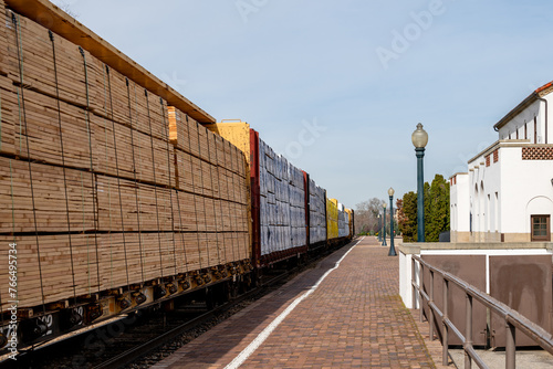 Train travels past a depot loaded with cargo