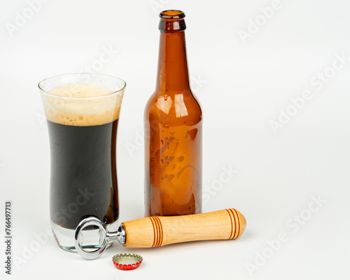 Poured Bottle of beer with bottle opener and glass
