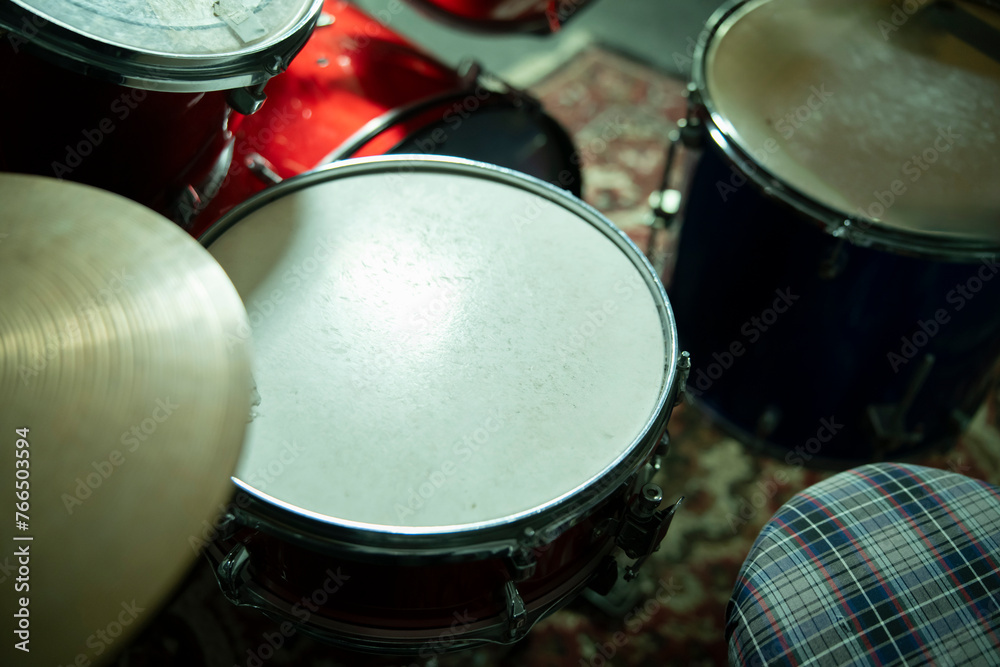 Obraz premium Close-Up View of a Red Acoustic Drum Set With Cymbals and Stool in a Music Studio