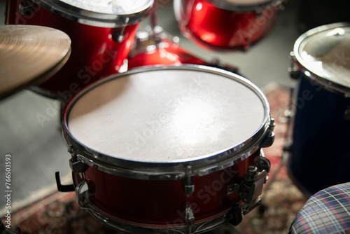 Close-Up View of a Red Acoustic Drum Set With Cymbals and Stool in a Music Studio