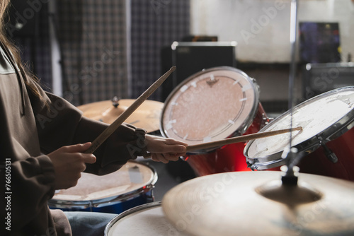 Drummers Hands Holding Sticks Mid-Performance on a Drum Set