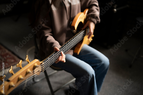 Young Musician Playing electric Guitar in a Studio Setting During a Rehearsal, playing accord