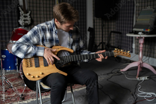 Young Musician Playing electric Guitar in a Studio Setting During a Rehearsal, playing accord