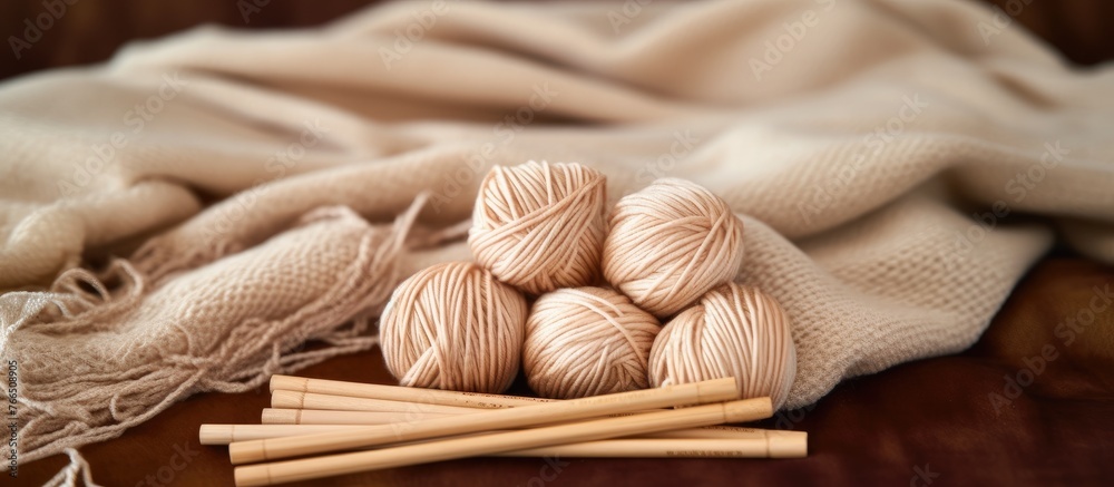 A detailed close-up view of colorful yarn and metallic knitting needles neatly arranged on a wooden table, ready for a knitting project A detailed close-up view of colorful yarn and metallic knitting needles neatly arranged on a wooden table, ready for a knitting project