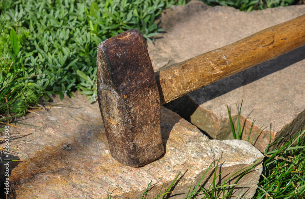big old hammer on granite stone. blurred background. big old hammer on granite stone. blurred background.
