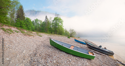 fog over lake Sylvensteinsee, gravel beach with boats, spring landscape upper bavaria photo