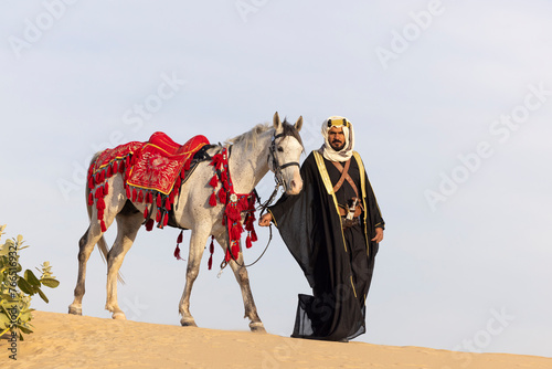 Saudi Man with his white stallion in a desert