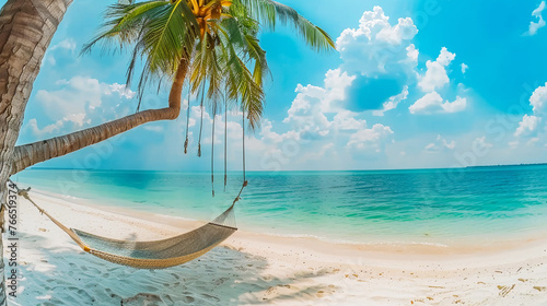 Photo of hammock fixed on palm trees near the shore of the azure sea. Summer vacation concept in tropical places.