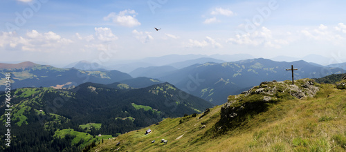 krajobraz górski z małą chatką i owieczkami na szczycie krzyż