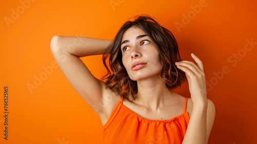 Shocked European woman while watching look above isolated blue background .Image of excited screaming young woman standing isolated over orange background. Looking camera.Portrait American woman