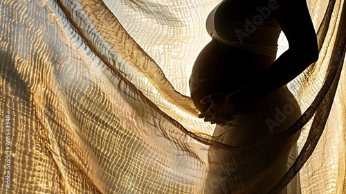 Shadow silhouette of a female pregnant behind a textured fabric
