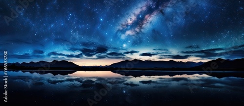 The Milky Way is mirrored in the tranquil waters of a lake under the night sky, creating a breathtaking natural landscape art piece © TheWaterMeloonProjec
