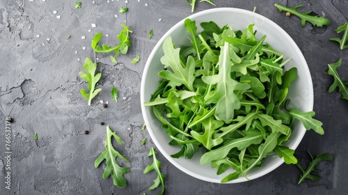 Arugula leaves in a white bowl  placed alone in a vertical position.