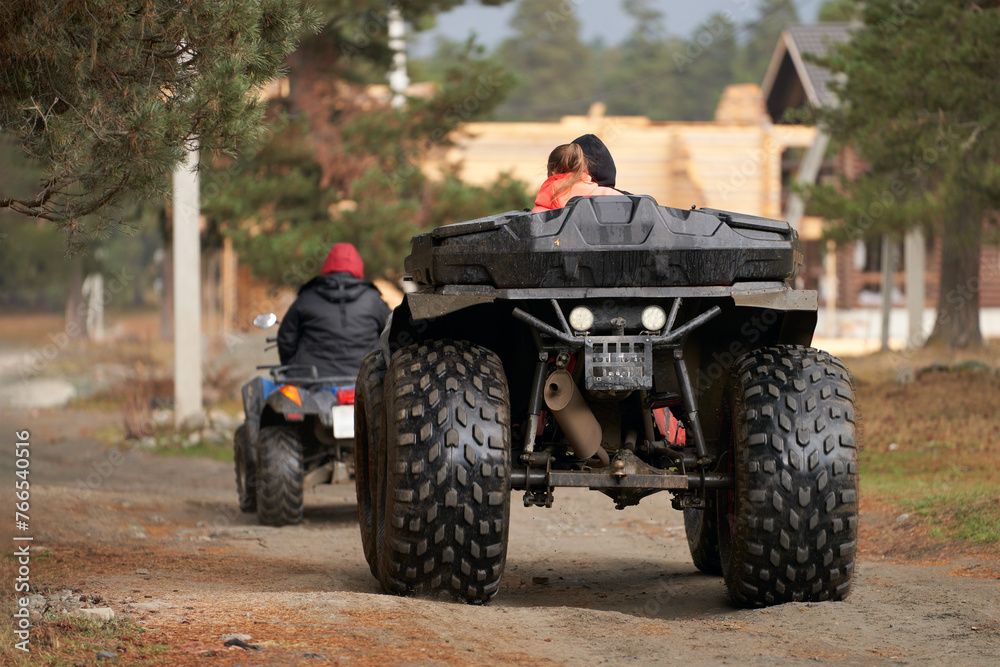 Fototapeta premium A group of tourists on all-terrain vehicles returning to a campsite in the mountains.