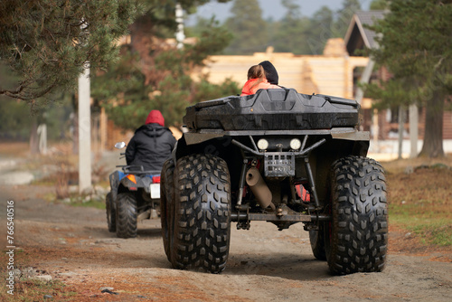 A group of tourists on all-terrain vehicles returning to a campsite in the mountains.