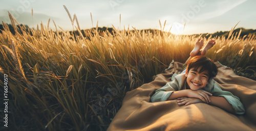 Hintergründe Vorlagen draußen im Freien ein Junge liegt glücklich lächelnd barfuß auf einer Decke im hohen grünen Gras in Sommer Sonne Strahlen genießt Freizeit Urlaub Ferien Natur Freiheit Schönheit  photo