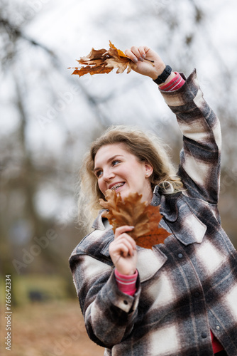 Woman Holding a Leaf and Having Fun in Park