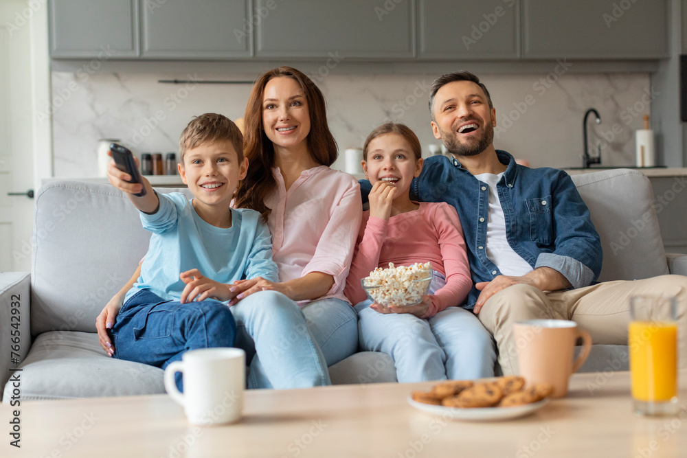 Happy european family with their preteen kids watching tv together at home Happy european family with their preteen kids watching tv together at home