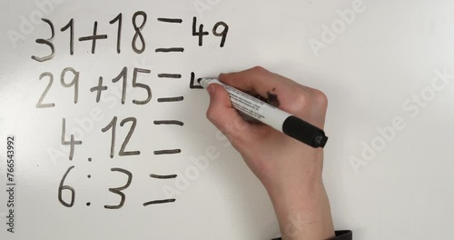 Hand writing mathematic examples on whiteboard. 4K stop motion animation.