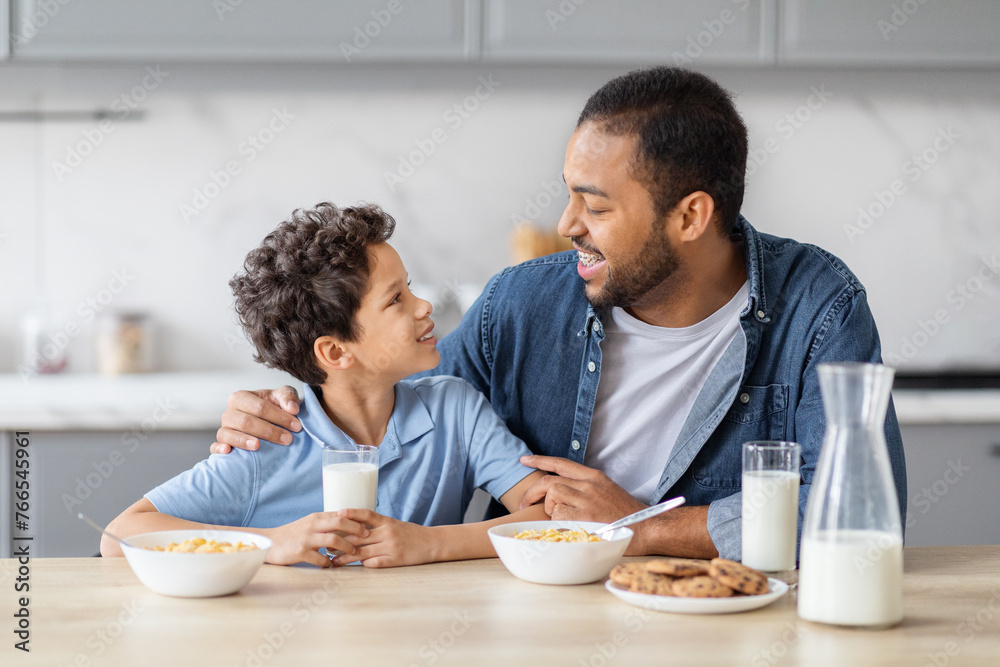 Happy african american father and son have breakfast together Happy african american father and son have breakfast together