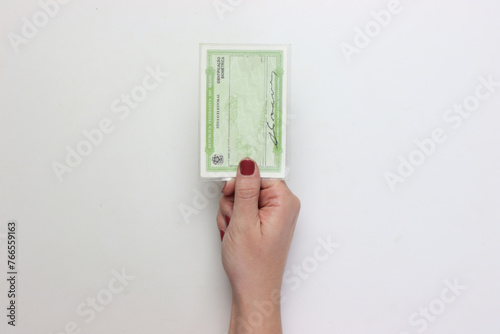 Brazil voter registration card in a woman’s hand isolated in a white background 
