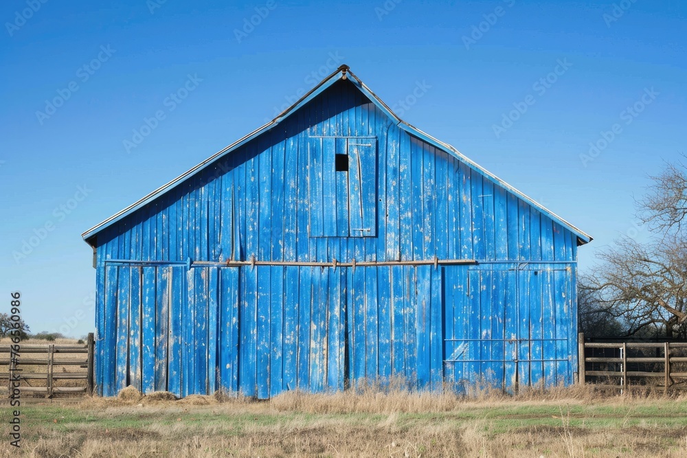Obraz premium Vintage blue barn with a rustic appearance in a tranquil rural landscape