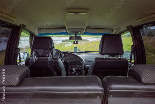 the view from inside the SUV to the river and the green meadow. the concept of travel and tourism, outdoor recreation.