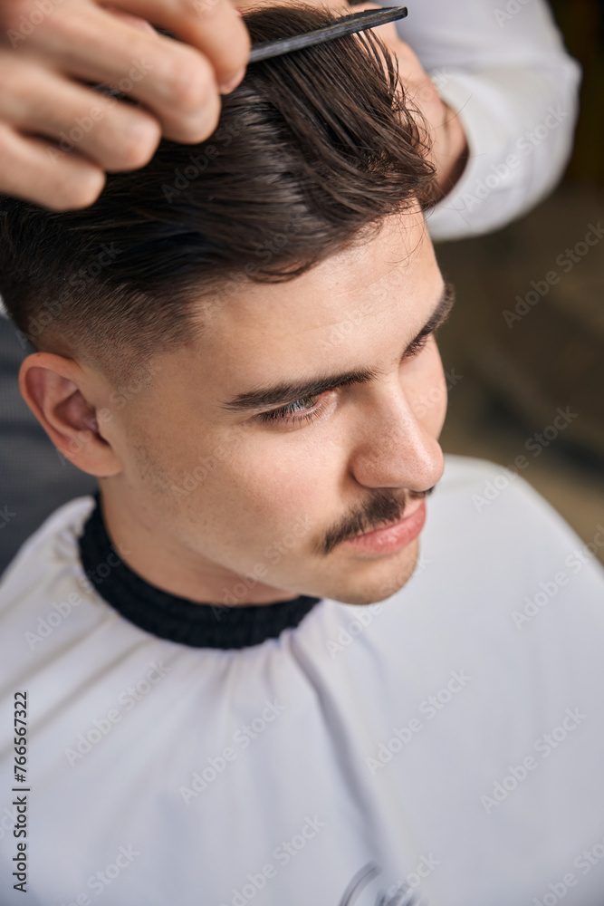 Fototapeta premium Man hairstylist serving client with mustache