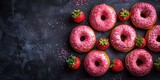Layered against a black backdrop are some delicious strawberry donuts, each topped with a luscious pink glaze and a delectable filling.