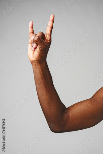 Hand Making the Rock N Roll Sign Against a Plain Gray Background