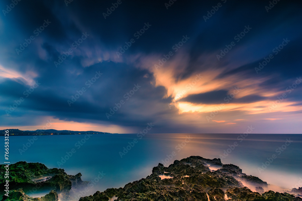 Dusk falls before the storm over a tropical rocky beach in Jamaica - Long Exposure