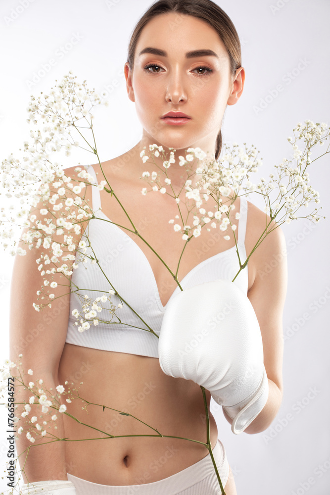 © Dimid - Portrait of attractive girl in white boxing gloves with healthy clean skin and beautiful make-up. She holds a branch with white flowers. Aesthetic cosmetology and makeup concept. © Dimid - Portrait of attractive girl in white boxing gloves with healthy clean skin and beautiful make-up. She holds a branch with white flowers. Aesthetic cosmetology and makeup concept.