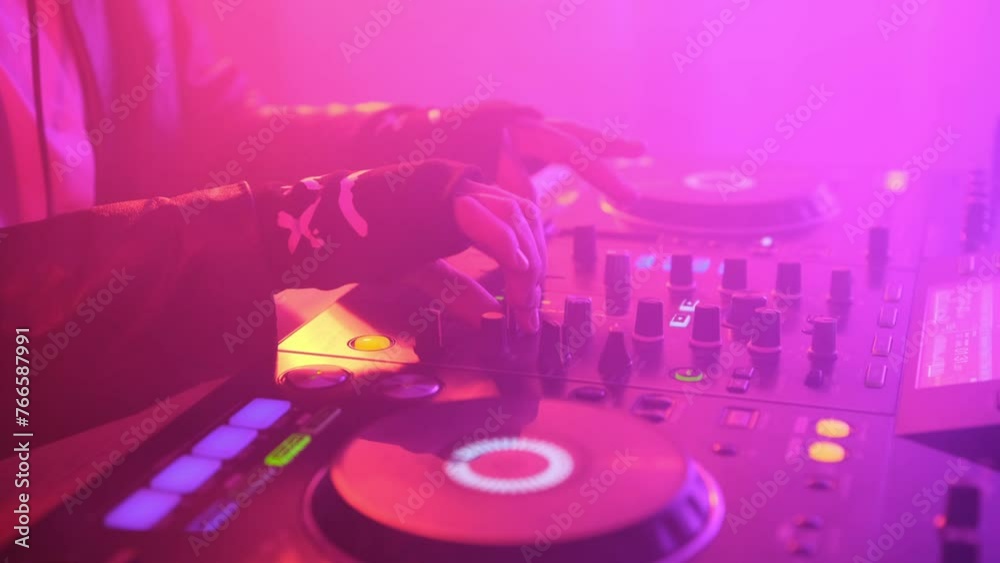DJ plays music in a nightclub with multicolor effect and smoky room. DJ plays music in a nightclub with multicolor effect and smoky room.