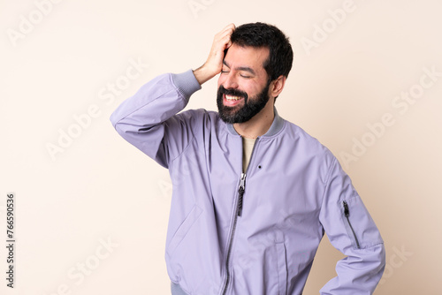 Caucasian man with beard wearing a jacket over isolated background smiling a lot
