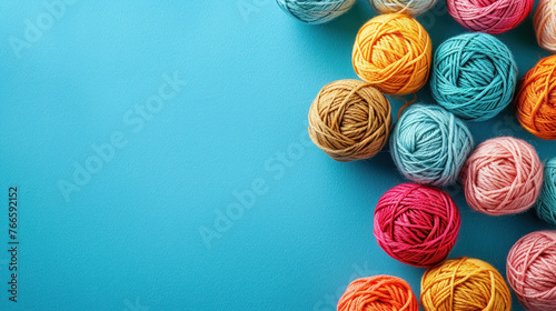 Flat lay colorful balls of yarn on blue background with copy space, banner with collection of colors woolen skeins for knitting thread