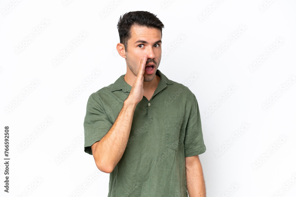 Young handsome man over isolated white background whispering something with surprise gesture while looking to the side Young handsome man over isolated white background whispering something with surprise gesture while looking to the side