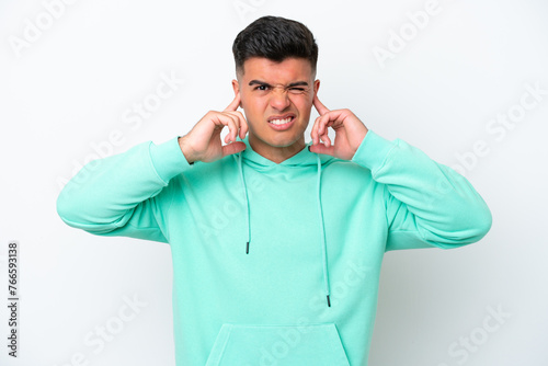 Young caucasian handsome man isolated on white background frustrated and covering ears © luismolinero