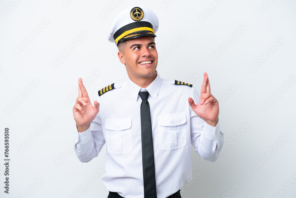 Airplane pilot caucasian man isolated on white background with fingers crossing Airplane pilot caucasian man isolated on white background with fingers crossing